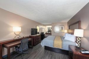 a hotel room with a bed and a desk and a computer at Colonial Inn Camden in Camden +4 photos