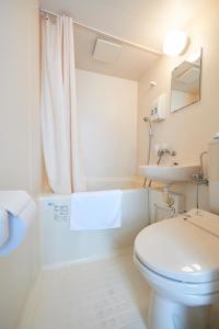 a white bathroom with a toilet and a sink at Select Inn Shimada Ekimae in Shimada