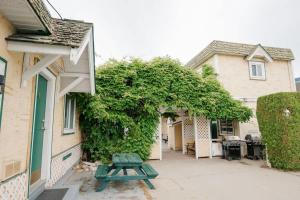 a green picnic table in front of a house at Studio Suite 8 Green Gables Resort in Osoyoos