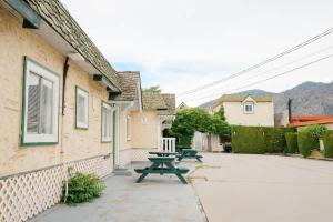 a picnic table next to a building with mountains in the background at Studio Suite 8 Green Gables Resort in Osoyoos +42 photos