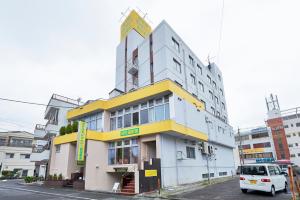 a building with a van parked in front of it at Select Inn Shimada Ekimae in Shimada