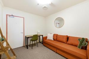 a living room with a couch and a table at City-Edge 1-Bed Apartment with Pool Access in Canberra