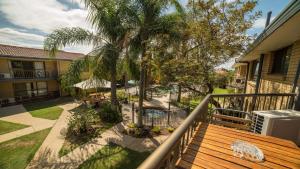 a balcony with a wooden bench and a palm tree at Jadon Place Holiday Apartments in Gold Coast