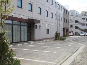 an empty parking lot in front of a building at Hotel Green Palace in Sendai