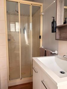 a bathroom with a shower and a white sink at Cunnamulla Tourist Park in Cunnamulla