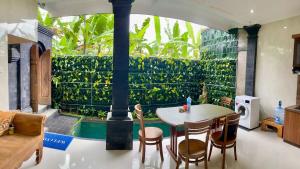a living room with a table and chairs and a pool at Dede House 1 Private Pool in Ubud