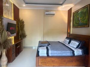 a bedroom with a bed with a desk and a tv at Dede House 1 Private Pool in Ubud