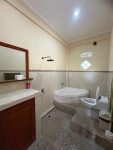 a bathroom with a sink and a toilet and a mirror at Dede House 1 Private Pool in Ubud +6 photos