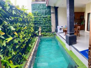 a swimming pool in the middle of a house with plants at Dede House 1 Private Pool in Ubud