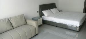 a bedroom with a bed and a couch in it at CondoApsara in Phnom Penh