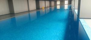 a large swimming pool with blue water in a building at CondoApsara in Phnom Penh +13 photos