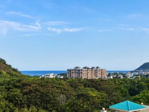 a view of a city from a hill with a blue roof at The capital hotel in Visakhapatnam