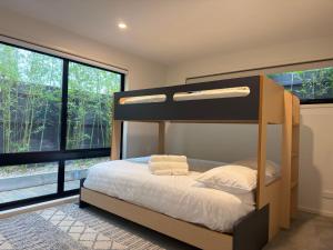 a bedroom with a bunk bed and large windows at La Sabbia - Rosebud in Rosebud