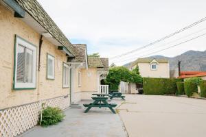 a picnic table next to a building with mountains in the background at 1 BR Suite 9 at Green Gables Resort in Osoyoos
