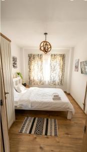 a bedroom with a large bed and a chandelier at Apartament Daria in Târgu Ocna