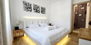 a bedroom with a white bed with towels on it at Apartament Daria in Târgu Ocna +21 photos