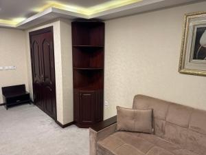 a living room with a couch and a book shelf at Sayohat Hotel in Tashkent +49 photos