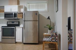 a kitchen with a stainless steel refrigerator and a microwave at the blossom stay in Burnaby +4 photos