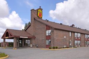 a large brick building with a sign on top of it at Super 8 by Wyndham Timmins ON in Timmins
