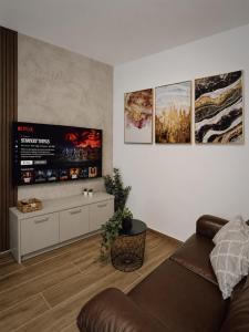a living room with a couch and posters on the wall at New Apartment - 3 min to Airport - 10 min to Valletta in Gudja