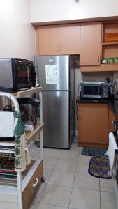 a kitchen with a stainless steel refrigerator and a microwave at Al-Fayed Property in Manila
