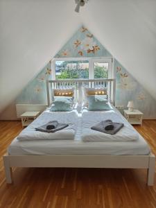 a bedroom with a white bed with a pointed roof at Esplanaadi Villa in Pärnu