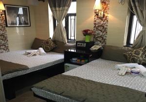 2 Betten in einem Zimmer mit Fenstern in der Unterkunft Skystar Hostel in Hongkong
