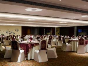 a banquet room with tables and chairs and tablesktop at Grand Mercure Vadodara Surya Palace in Vadodara +132 photos