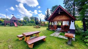 a small cabin with benches in a park at Willa POŚREDNIA - widok na Tatry z każdego pokoju in Zakopane