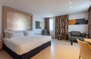 a bedroom with a large bed and a living room at Meliá Sevilla in Seville