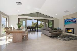 a living room with a table and a couch and a fireplace at Woodbine Waters Lakehouse in Yarrawonga
