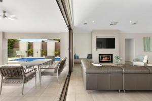 a living room with a couch and a table and a fireplace at Woodbine Waters Lakehouse in Yarrawonga +18 photos