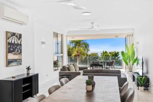a living room with a couch and a table at Bellevue At Trinity Beach in Trinity Beach