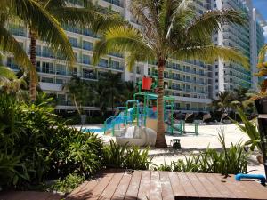 a playground in front of a large building at Azure Tropical Paradise in Manila
