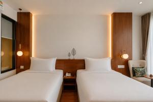 a hotel room with two beds and a chair at The Scenic Hotel in Phnom Penh +70 photos