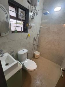 a bathroom with a toilet and a sink at Prakruthi Hill View 3BHK Entire Villa in Nandi +14 photos