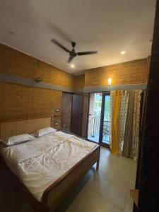 a bedroom with a bed and a ceiling fan at Prakruthi Hill View 3BHK Entire Villa in Nandi