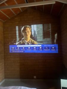a tv on a brick wall with a man on it at Prakruthi Hill View 3BHK Entire Villa in Nandi