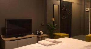 a bedroom with a flat screen tv and a bed at The Mansion Pakchong in Pak Johng