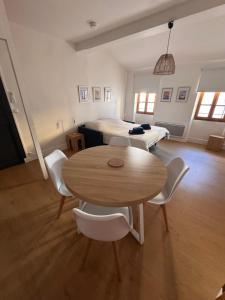 a room with a bed and a table and chairs at Studio climatisé in Narbonne +4 photos