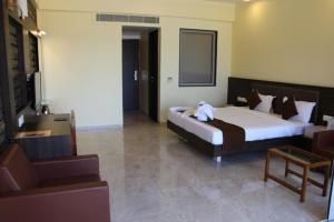 a hotel room with a bed and a chair at Krishna Beach Resorts - Diu in Diu