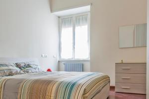 a bedroom with a bed and a dresser and a window at So Suite Rome in Rome