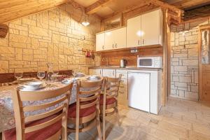 a kitchen with a table and chairs and a stove at Pivka Na Meji Resort in Pivka