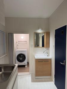 a small kitchen with a sink and a washing machine at 一軒家貸切 THREE FIELD Kobe Nakayamate in Kobe +30 photos