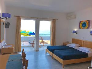 a bedroom with two beds and a view of the ocean at Kanakis Blue Beach Apartments in Petres