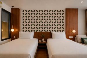 two beds sitting next to each other in a room at The Scenic Hotel in Phnom Penh