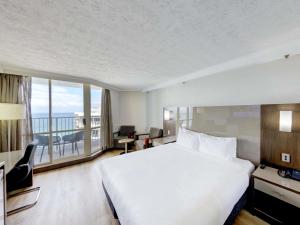a hotel room with a large bed and a large window at Novotel Surfers Paradise in Gold Coast