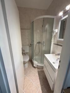 a bathroom with a shower and a toilet and a sink at Beach Rooms Split in Split +54 photos