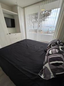 a bedroom with a bed and a large window at Costa del mar in Quintero
