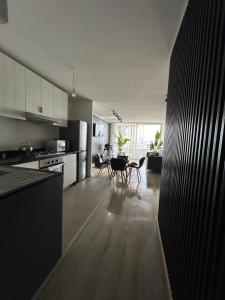 a kitchen with white cabinets and a table and chairs at Costa del mar in Quintero +15 photos